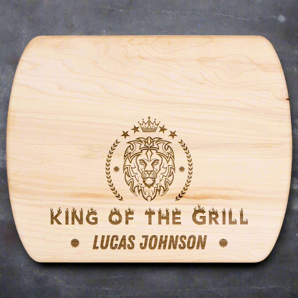 King of the Grill Personalized Charcuterie Board with image of lion crest on the sides of the line with 4 stars and crown at the top. personalized name at the bottom of King of the grill. King of the grill written in block letters with a fire effect on each letter.